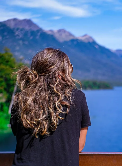 Samantha looking out over mountains and water while traveling
