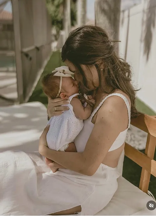 Samantha holding her child in soft morning light